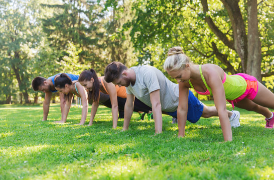 group of friends or sportsmen exercising outdoors