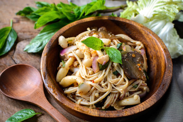 thai spicy mushroom salad in wooden bowl