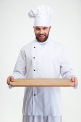 Male chef cook holding wooden chopping board