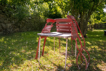 three old, red folding chairs leaning against a table