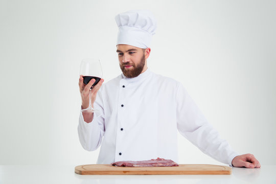 Handsome male chef cook degusting wine