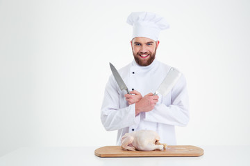 Male chef cook standing with knifes and chicke