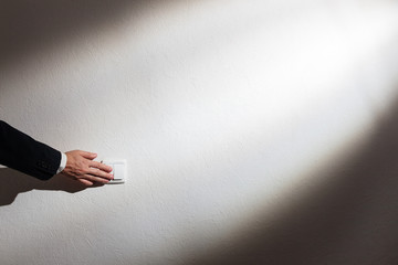Saving energy - an eco-friendly lifestyle. Man's hand turns off the light