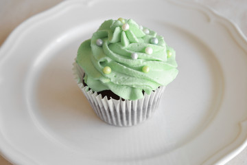 Homemade chocolate cupcake with green frosting