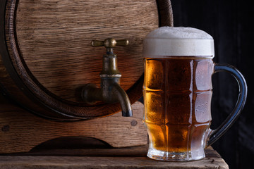Glass of beer and vintage beer barrel still life