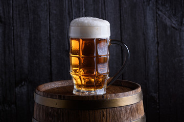 Beer glass on old beer barrel dark still life