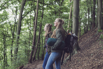 Twinsister standing on trail in forest.