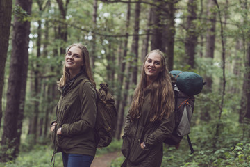 Obraz premium Happy twin sister hiking in forest.
