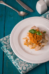 Cod with sauce Romanesco on the cyan table top view