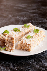 oat bar with coconut with mint on a plate, close up