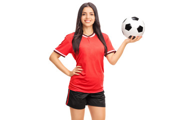 Female soccer player in red jersey holding a ball