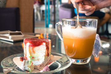 Milk tea with strawberry cake in cafe.