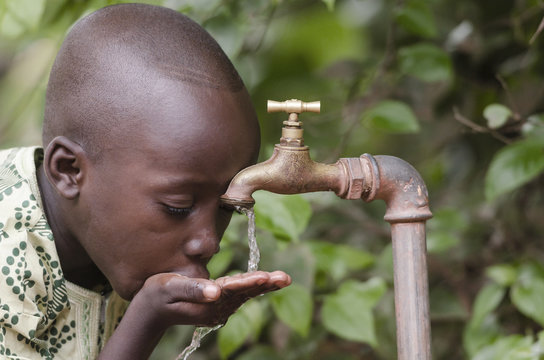 Water scarcity in the world symbol. African boy begging for water. In places like sub-Saharan Africa, time lost to gather water and suffering from water-borne diseases is limiting people's lives.