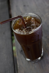 Ice black coffee on wooden table