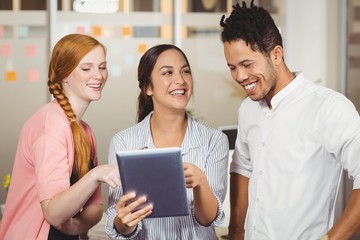 Colleagues laughing and looking at tablet