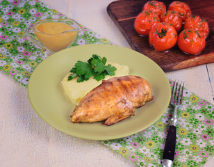 Grilled chicken fillet with mashed potatoes and grilled tomatoes. Rustic style.