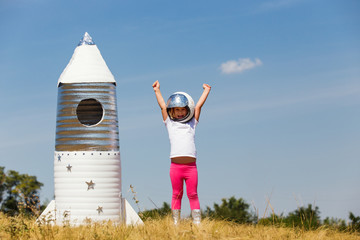 Happy child dressed in an astronaut costume playing with hand ma