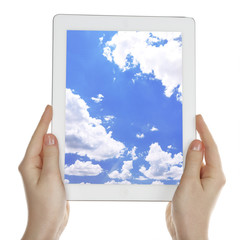 Hands holding tablet PC with sky in screen. Cloud computing concept