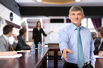 Businessman giving his hand for a handshake and business people