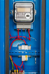 Electric power meter with AMR (automatic meter reading) feature installed in blue steel enclusure
