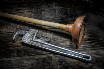 Old plunger and pipe wrench.