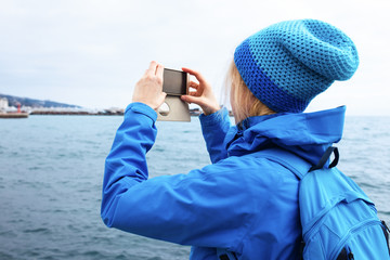 Young woman taking picture with smartphone. Travel concept