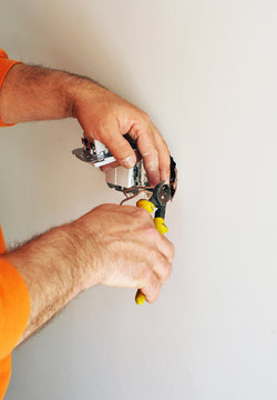 Un electricista experto instalando interruptores eléctricos nuevos
