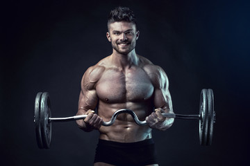 Fototapeta na wymiar Muscular bodybuilder guy doing exercises with big dumbbell