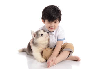 Cute asian boy sitting with siberian husky puppy