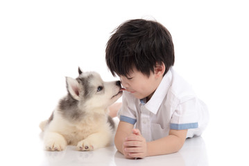 Cute asian boy and siberian husky puppy lying