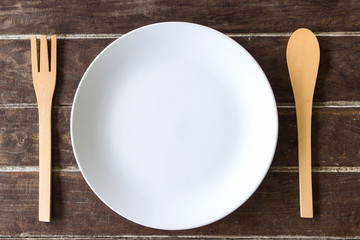 wooden fork and spoon and empty plate