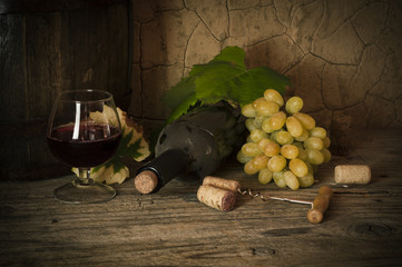 still life with red wine and barrel on old wood