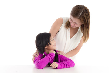 Smiling asian mother and young daughter on white background