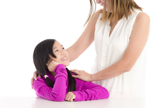Smiling asian mother and young daughter on white background