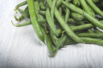 Group of green beans on the wood.
