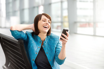 Fototapeta premium Older woman reading text message and laughing