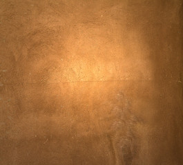 Naklejka premium Brown painted plaster pattern background with spotlight and place for your design or text
