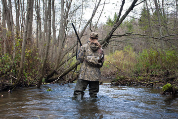 Naklejka premium woman hunter in waders on the river