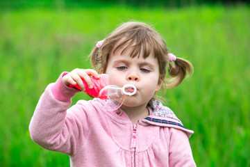 child girl blowing soap bubbles