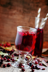 Hot mulled wine with cranberries on the background of autumn, se