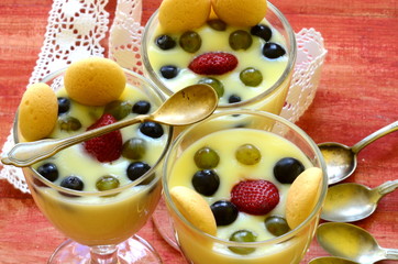 Hot homemade vanilla pudding with strawberries and vine berries