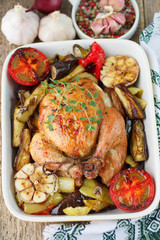 Baked chicken with vegetables and herbs. Dinner in a rustic style