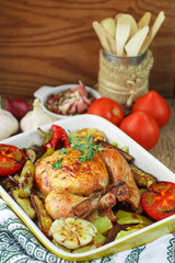 Baked chicken with vegetables and herbs. Dinner in a rustic style