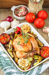 Baked chicken with vegetables and herbs. Dinner in a rustic style