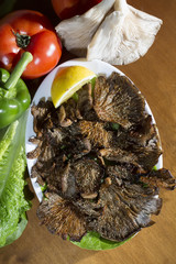 Grilled mushrooms with lemon on a plate, with ingredients on the