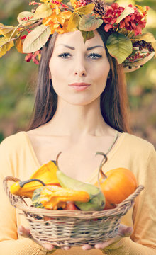 portrait of beautiful girl with autumn leaves and pumpkins