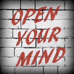 The words Open Your Mind in red text on a brick wall background, processed in black and white for effect