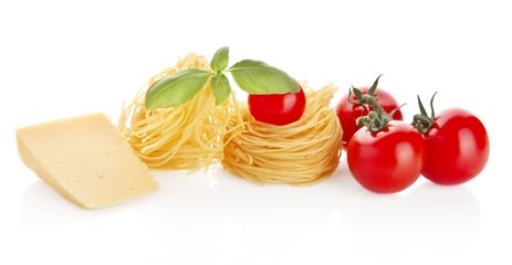 Studio shot of tomatoes,tagliatelle,basil and cheese on white