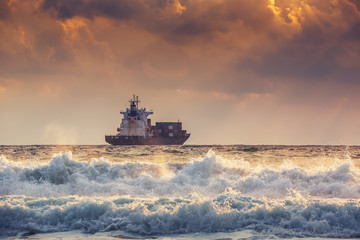 Obraz premium Cargo ship with containers in sunrise light