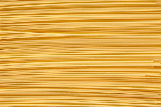Background made of raw pasta stacked horizontally